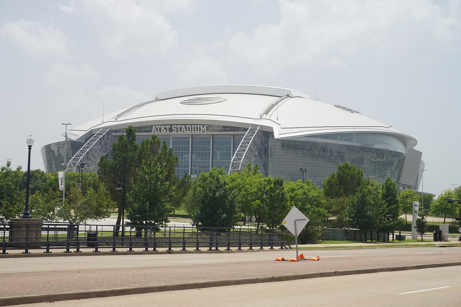 The exterior of AT&T Stadium in Arlington, Texas, seen from ground level on a clear summer day